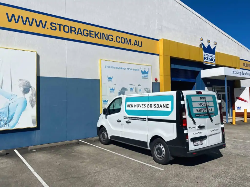 A moving van parked in front of a storage warehouse